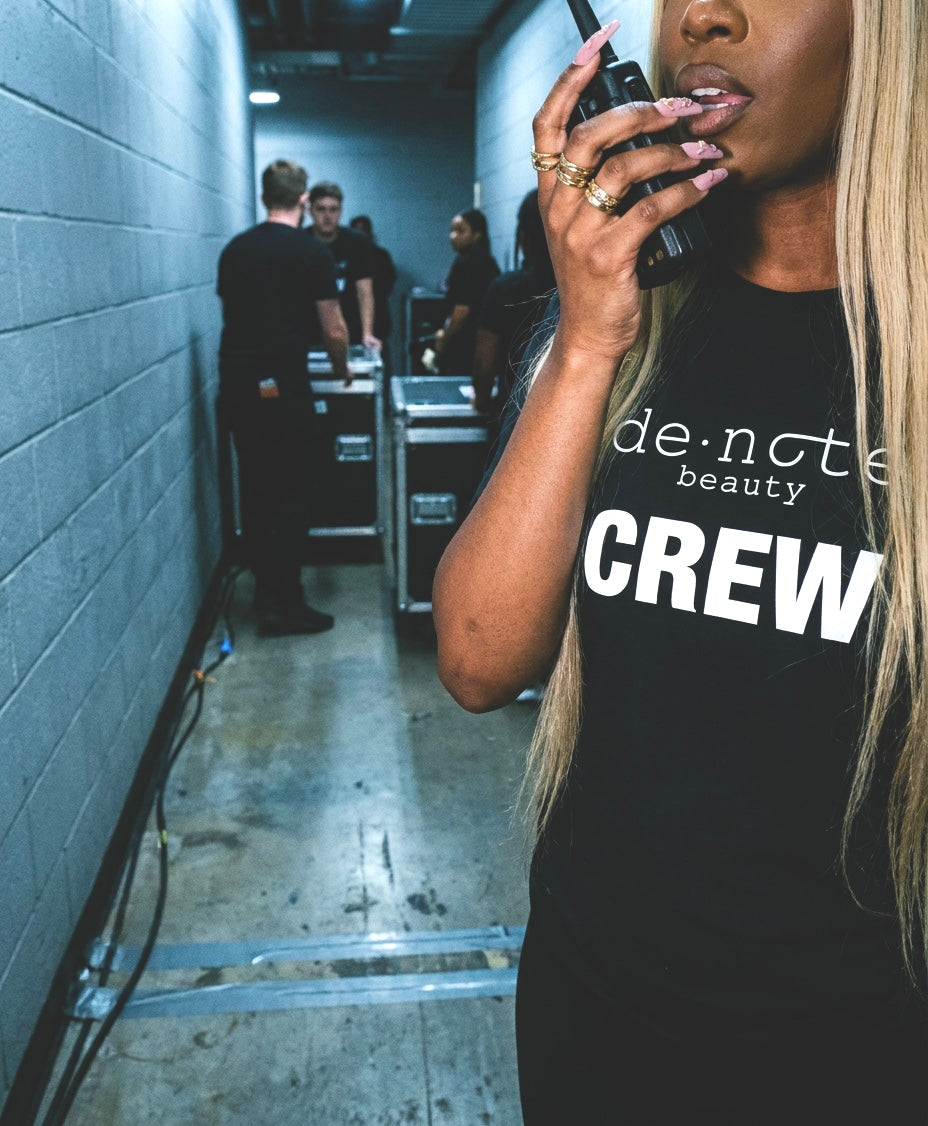 A denote beauty crew member on a walkie backstage